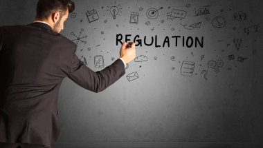 İş adamı, REGULATION yazıtları ve iş stratejisi konseptiyle yaratıcı bir fikir çizimi yapıyor.