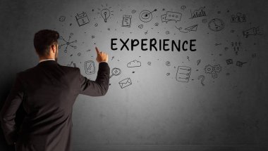 İş adamı, ExperIENCE yazıtları ve iş stratejisi konseptiyle yaratıcı bir fikir çizimi yapıyor.