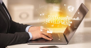 Diz üstü bilgisayarda çalışan bir iş adamının yan görünüşü SuSTAINable DEVELOPMENT yazıtları, modern iş konsepti
