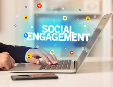 SOSYAL ENGAGEMENT yazıtları ve sosyal medya kavramına sahip dizüstü bilgisayar kullanan serbest çalışan kadın