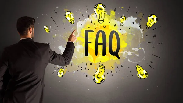 businessman drawing colorful light bulb with FAQ abbreviation, new technology idea concept