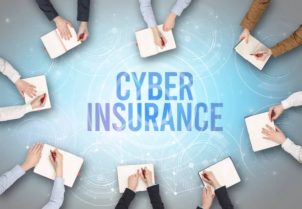 Group of people in front of a laptop with CYBER INSURANCE insciption, web security concept