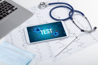 Beyaz yüzeyde TEST yazıtı, salgın konsepti içeren tablet pc ve doktor araçları