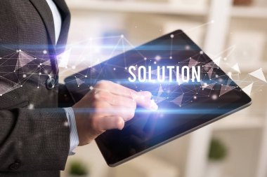 SOLUTION yazıtları ve modern iş teknolojisi kavramı olan tablet kullanarak elleri kapat