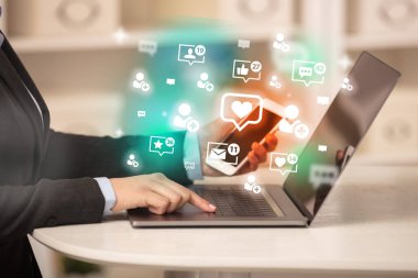 Laptop 'ta kalp ikonları ve sosyal medya konseptiyle sörf yapan genç kişi