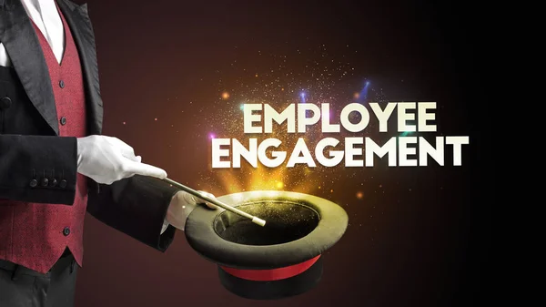 Illusionist is showing magic trick with EMPLOYEE ENGAGEMENT inscription, new business model concept