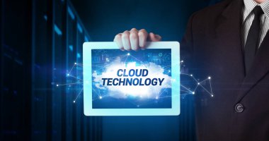 Tablet üzerinde çalışan genç iş adamı ve yazıyı gösteriyor: CLOUD TEKNOLOJİ