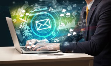 Multimedya ekranından gelen zarf simgesiyle modern bir dizüstü bilgisayarda el yazısı, sezgisel teknoloji kavramı