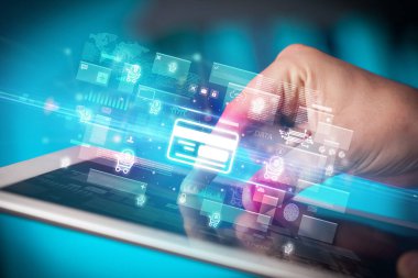 İçinde kredi kartı simgeleri olan tablet kullanan bir elin yakın çekimi, dijital para birimi kavramı