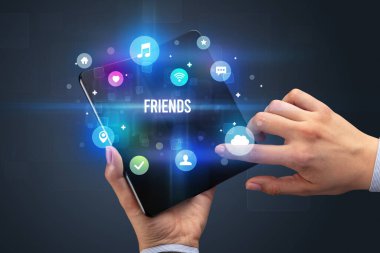 İş adamı elinde Friends yazısıyla katlanabilir bir akıllı telefon tutuyor, sosyal medya kavramı