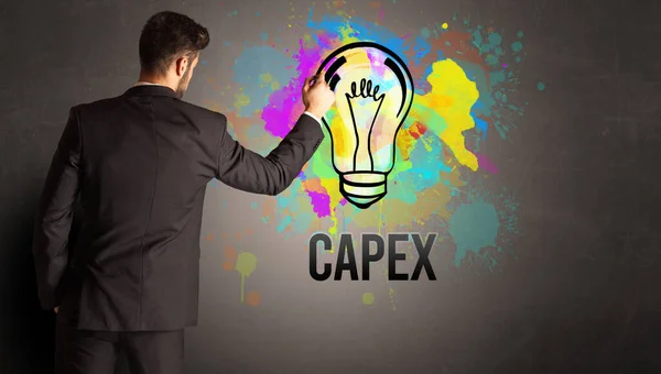 Businessman Drawing Colorful Light Bulb Capex Inscription Textured Concrete Wall — Stock Photo, Image