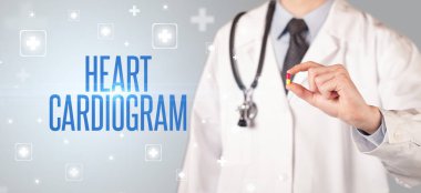 Kalp Kardiyogramı yazıtlı, tıbbi konseptli ilaç veren bir doktorun yakın çekimi.