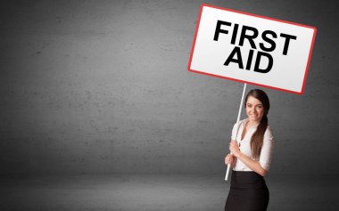 İş adamı elinde ilk yardım yazısıyla bir trafik işareti tutuyor. Yeni fikir kavramı.