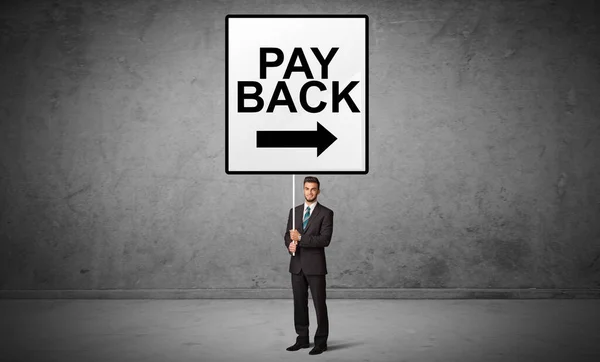 Persona Negocios Con Una Señal Tráfico Con Inscripción Pay Back —  Fotos de Stock