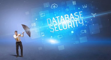 Siber saldırı ve Veritabanı Güvenliği yazıtları ve çevrimiçi güvenlik konseptiyle savunma yapan bir iş adamı.