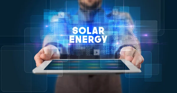 在平板电脑上工作的年轻商人并展示题词 Solar Energy — 图库照片