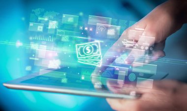 Bir elin, içinden nakit para ikonları çıkan tablet kullanılarak yakın plan fotoğrafı, dijital para birimi kavramı