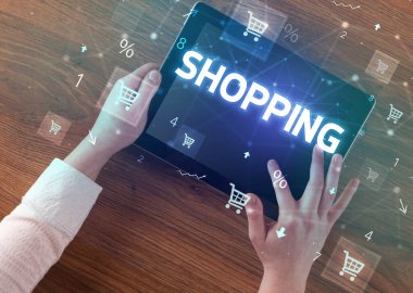 Alışveriş yazıtları ve online alışveriş konseptiyle el ele tutuşma tabletinin yakın çekimi
