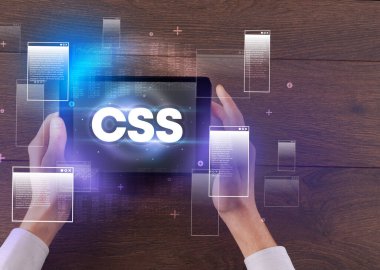 CSS kısaltmalı, modern teknoloji kavramlı el ele tutuşma tabletinin yakın çekimi