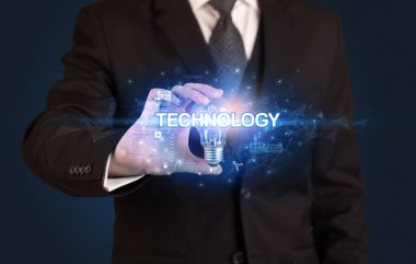 TECHNOLOGY yazıtlı ampul tutan iş adamı, yenilikçi teknoloji kavramı