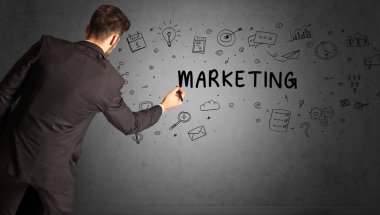 İş adamı, MARKETING yazıtları ve iş stratejisi konseptiyle yaratıcı bir fikir çizimi yapıyor.