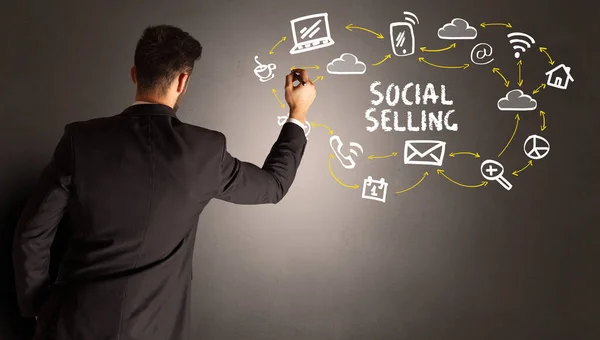 businessman drawing social media icons with SOCIAL SELLING inscription, new media concept