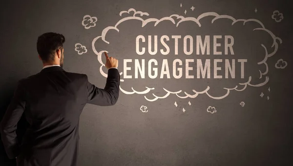 businessman drawing a cloud with CUSTOMER ENGAGEMENT inscription inside, modern business concept