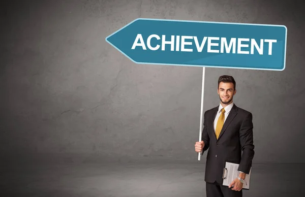 Joven Hombre Negocios Casual Celebración Señal Tráfico Con Inscripción Achievement —  Fotos de Stock