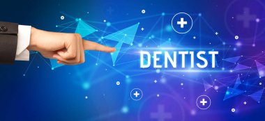 Kesilmiş ellerin yakın çekimi DENTIST yazısını işaret ediyor, tıbbi konsept