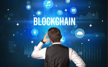 BLOCKCHAIN yazıtlarına sahip bir işadamının arka görünümü, modern teknoloji kavramı