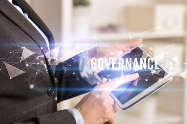 GOVERNANCE yazıtları ve modern iş teknolojisi kavramı olan tablet kullanarak elleri kapat