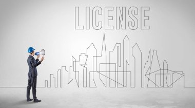 LICENSE Yazı, Mühendislik ve Mimarlık konsepti olan sağlam şapkalı bir işadamı.
