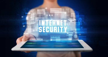 Tablet üzerinde çalışan genç iş adamı dijital işareti gösteriyor: INTERNET GÜVENLİĞİ
