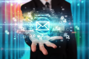 İş adamı elinde birden fazla teknoloji sembolü olan bir zarf simgesi tutuyor.