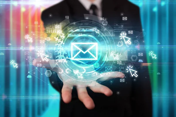 İş adamı elinde birden fazla teknoloji sembolü olan bir zarf simgesi tutuyor.