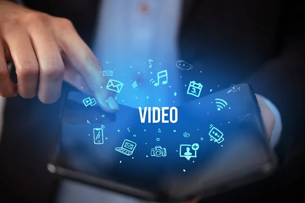 Üzletember Kezében Egy Összecsukható Okostelefon Video Felirattal Szociális Média Koncepció — Stock Fotó