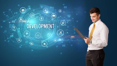 Teknolojiyle ilgili ikonlar ve DEVELOPMENT yazıtları ve modern teknoloji kavramı önünde düşünen iş adamı