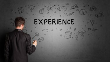 İş adamı, ExperIENCE yazıtları ve iş stratejisi konseptiyle yaratıcı bir fikir çizimi yapıyor.