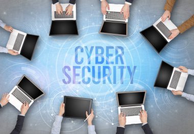 Bir dizüstü bilgisayarın önünde CYBER GÜVENLİK içgüdü, web güvenlik kavramı olan bir grup insan