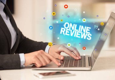ONLINE REVIEWS yazıtlı, Sosyal medya konseptli dizüstü bilgisayar kullanan serbest çalışan kadın