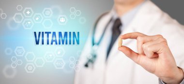 Doktorun sana VITAMIN yazıtlı bir hap verdiği yakın plan, tıbbi konsept.