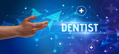 Kesilmiş ellerin yakın çekimi DENTIST yazısını işaret ediyor, tıbbi konsept