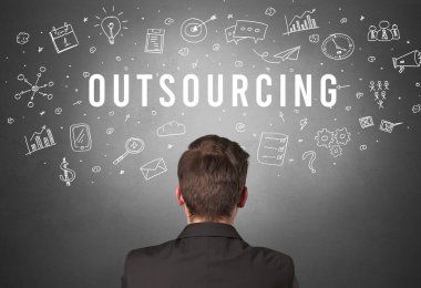 OutTSOURCING yazıtları, modern iş konsepti olan bir iş adamının arka görüşü