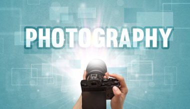 Fotografik yazı ve seyahat konseptiyle el ele tutuşan dijital kameranın yakın çekimi