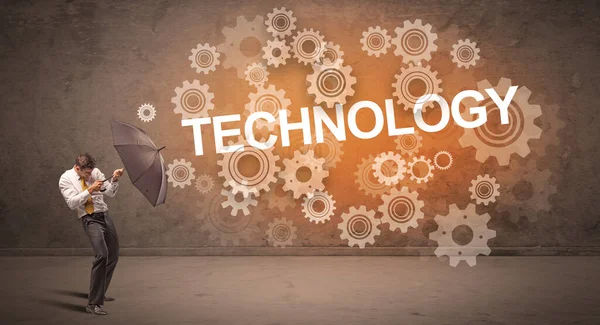 TECHNOLOGY yazıtlarından şemsiyeyle savunma yapan iş adamı, teknoloji kavramı