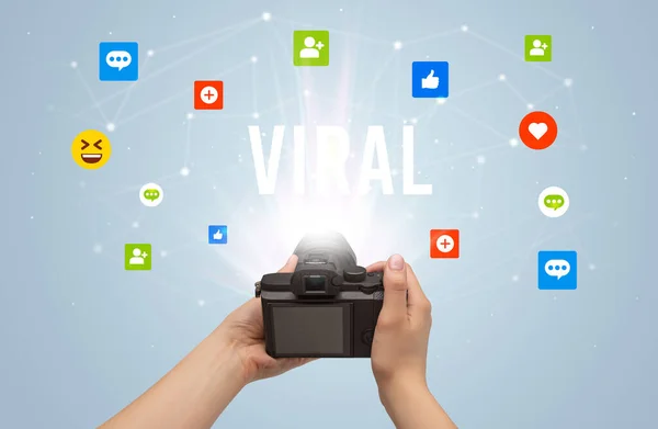 Using camera to capture social media content with VIRAL inscription, social media content concept