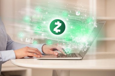 Dizüstü bilgisayarda zcash ikonlarıyla hisse senedi piyasasını izleyen genç adam.