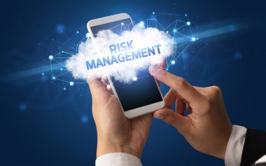 RISK MANAGEMENT yazıtlı akıllı telefona dokunan kadın el, bulut işi konsepti