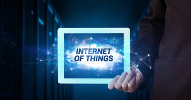 Tablet üzerinde çalışan genç iş adamı ve yazıtı gösteriyor: Nesnelerin İnterneti