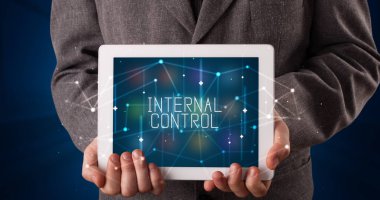 Tablet üzerinde çalışan genç iş adamı dijital işareti gösteriyor: INTERNAL CONTROL